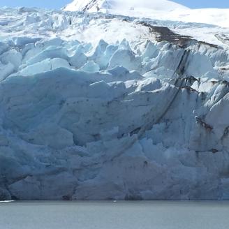 Portage Glacier is located on the Kenai Peninsula in Alaska within the Chugach National Forest. It is located south of Portage Lake and 4 mi west of Whittier, AK. Portage Glacier was a local name first recorded in 1898 by Thomas Corwin Mendenhall of the U.S. Coast and Geodetic Survey, so called because it is on a portage route between Prince William Sound and Turnagain Arm. Hundreds of years ago the glacier filled the entire Portage Valley. The blue color of the galcier is caused by all the oxygen being com