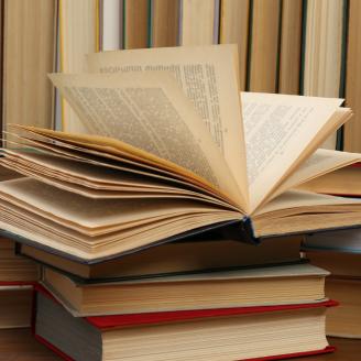 Many hardcover books as background, closeup.