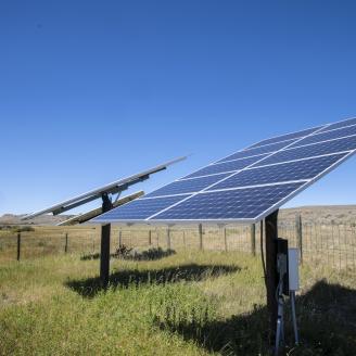 Solar panels at Sauerbier Ranches LLC, where producer Dan Doornbos (vest) and son-in-law ranch operator Ryan Ellis, were able to implement brush management practices and install a solar-powered (photovoltaic) electric well pump and distribution system with the help of U.S. Department of Agriculture (USDA) Natural Resources and Conservation Service (NRCS) John Wagoner (cowboy hat), at Sweetwater Basin, in southwest Montana, on August 27, 2019. Brush management practice has opened the rangeland for cattle to