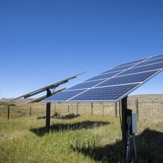 Solar panels at Sauerbier Ranches LLC, where producer Dan Doornbos (vest) and son-in-law ranch operator Ryan Ellis, were able to implement brush management practices and install a solar-powered (photovoltaic) electric well pump and distribution system with the help of U.S. Department of Agriculture (USDA) Natural Resources and Conservation Service (NRCS) John Wagoner (cowboy hat), at Sweetwater Basin, in southwest Montana, on August 27, 2019. Brush management practice has opened the rangeland for cattle to 