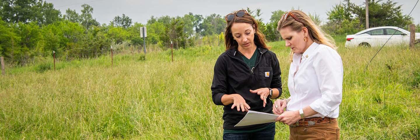 Mandi Bird showing NRCS Chief Bettencourt rotational grazing plans papers