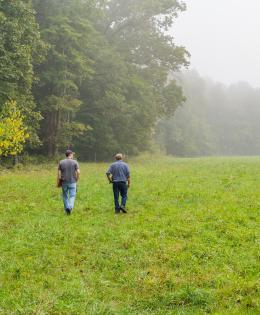 Indiana NRCS district conservationist Thomas Perkins (left) and Jerry Bates walk through a pasture at Bates' beef cattle operation in Cloverdale, IN.