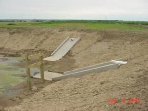 The concrete chutes for the pipe outlets for an agricultural waste holding pond at a feedlot.